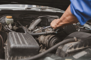 Car mechanic is inspecting the engine of a car coming in for repair at the center. Professional engine specialist, car repair, car breakdown. Car maintenance and repair concept.