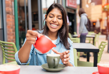 Indian woman sitting in street cafe drinking tea in the city Lifestyle concept