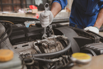Obraz premium Car mechanic is inspecting the engine of a car coming in for repair at the center. Professional engine specialist, car repair, car breakdown. Car maintenance and repair concept.
