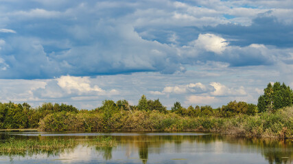 Fototapeta na wymiar clouds over lake anf forest