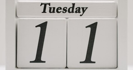 White wooden block calendar with changing days and dates during month, stop motion. Starting and ending of month. Closeup on wood cube with counting down numbers