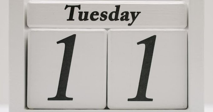White wooden block calendar with changing days and dates during month, stop motion. Starting and ending of month. Closeup on wood cube with counting down numbers