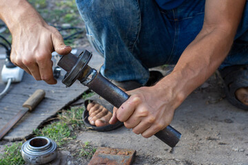 a man holds a welded metal part in his hands