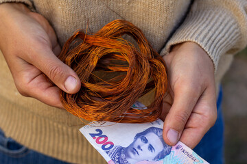 non-ferrous metal copper in the hands of a person and the money of Ukraine 200 hryvnias the price of copper in Ukraine