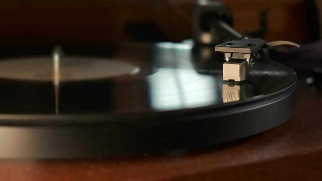 Detail of a turntable needle with platter spinning, slow motion 4K