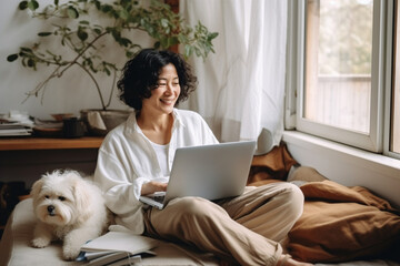 Happy middle-aged woman using laptop with her dog at cozy home.