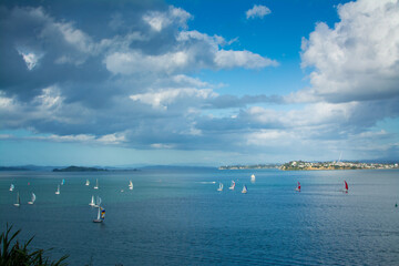 Sailing boats racing over calm waters of Auckland Harbour on a beautiful winter day. North Island,...