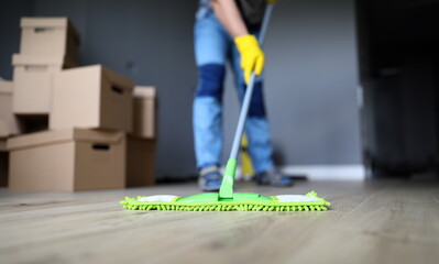 Close-up of male hands holding microfiber fluffy rag and mopping floors. Cleaning apartment after...