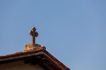 Croce sul tetto della chiesa contro il cielo azzurro. Simbolo religioso.