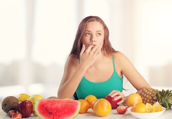 Happy young woman eats fresh fruits