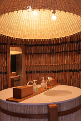 The sink in the hotel is made from bamboo and decorated with yellow lights.