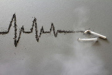 Cigarettes and cardiogram made of ash in fumes of smoke, harmful effects of cigarette smoking, creative concept 