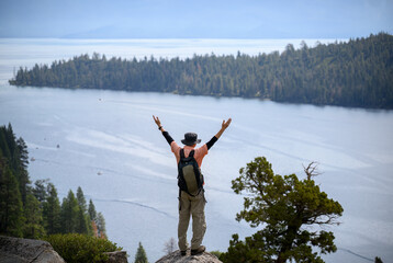 Fototapeta na wymiar Tourist raising arms at Emerald Bay. Lake Tahoe. California.