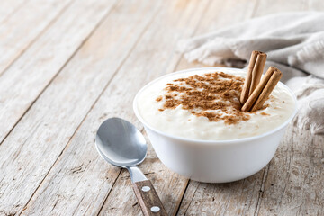 Arroz con leche. Rice pudding with cinnamon in bowl on wooden table. Copy space