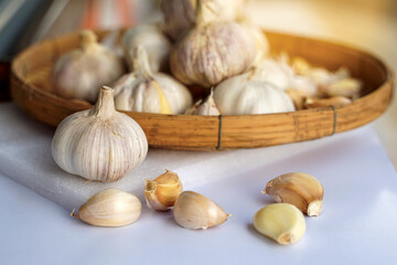 Garlic in a bamboo basket on a white background It is a medicinal plant in Thai kitchens used as an ingredient in food. It has a pungent odor and a spicy taste. It can be eaten both fresh and cooked.
