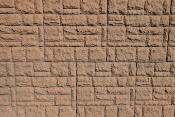 Dusty surface of brown concrete brick veneer wall with random layout