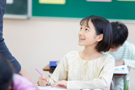 授業中に先生に教えてもらう女の子