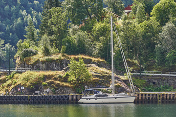 Sailing boat or yacht anchored in marina in the deep norwegian fjord during beautiful and calm...