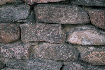 Retaining wall made of large large natural stones. Stacked stones at the base of the building. Close-up