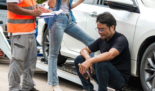 Drunk driver man holding alcohol bottle sitting near car after accident and insurance man checking damage lists