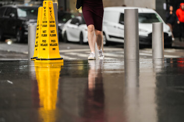 Wet floor. Yellow warning indicator with Wet floor message written in English and Spanish in New York, America.