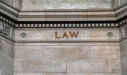 Law text wrote on the walls of a historical building. Concept image for law.