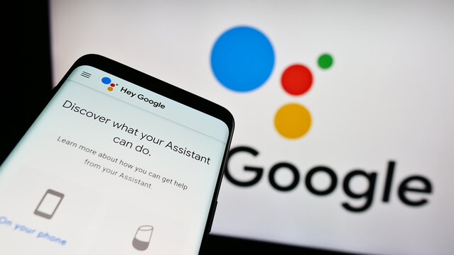 Stuttgart, Germany - 09-23-2023: Smartphone with website of virtual assistance software Google Assistant on screen in front of business logo. Focus on top-left of phone display.
