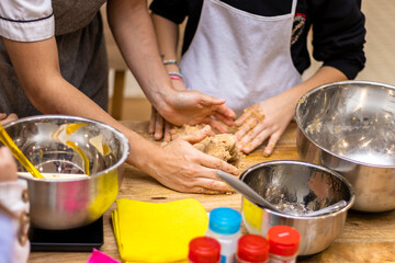 Christmas cookies workshop. Close-up of hands kneading cookies. - obrazy, fototapety, plakaty