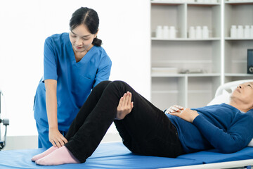 senior man doing exercise at clinic with physiotherapist. help of a personal trainer during a...