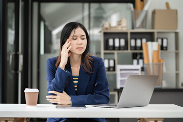 Stress businesswoman is sitting at table, under stress from working.