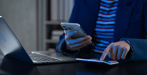 Business women or accountant working on laptop computer with business document, graph diagram and calculator on office table in office.