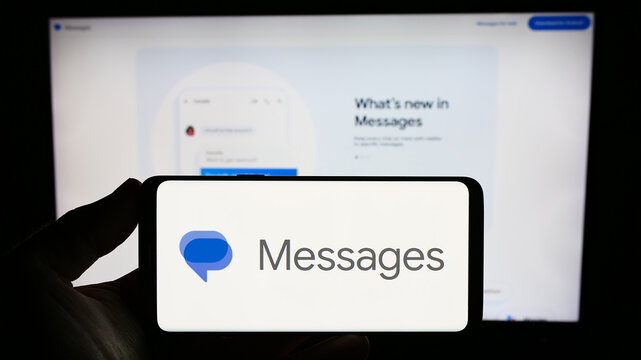 Stuttgart, Germany - 09-23-2023: Person holding smartphone with logo of instant messaging app Google Messages on screen in front of website. Focus on phone display.
