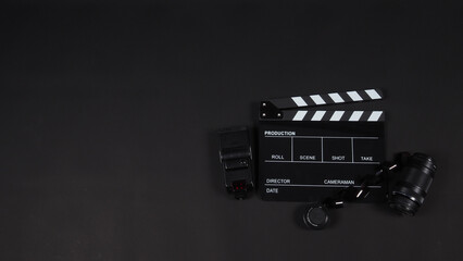 Clapperboard or movie slate with film,lens,flash light.It is used in video production , cinema industry on black background.
