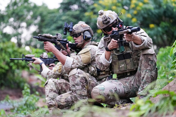 Military army soldiers tactical team, commando group moving cautiously in forest area, kneeling and...