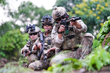 Military army soldiers tactical team, commando group moving cautiously in forest area, kneeling and...
