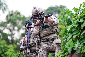 Military army soldiers tactical team, commando group moving cautiously in forest area, kneeling and...