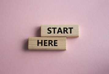 Start here symbol. Wooden blocks with words Start here Beautiful pink background. Business and Start here concept. Copy space.