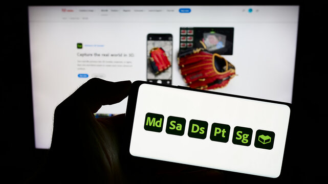 Stuttgart, Germany - 09-23-2023: Person holding mobile phone with logo of software product Adobe Substance 3D on screen in front of company web page. Focus on phone display.