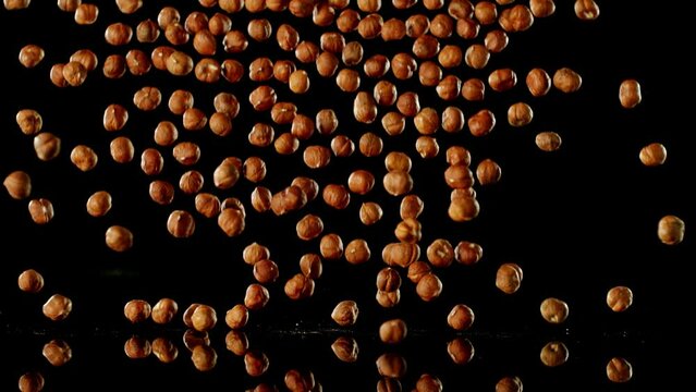 Super Slow Motion of Falling Hazelnuts with Reflection. Isolated on Black Background. Filmed on High Speed Cinema Camera, 1000fps.