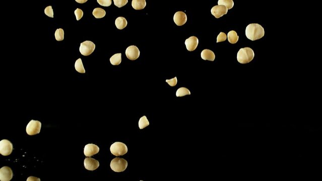 Super Slow Motion of Falling Macadams Nuts with Reflection. Isolated on Black Background. Filmed on High Speed Cinema Camera, 1000fps.