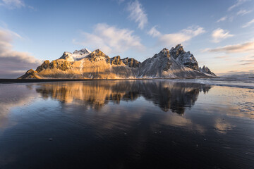 Picturesque view of black sand beach against cloudy sky