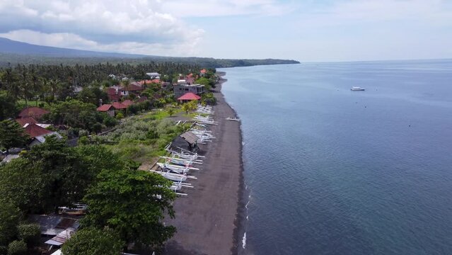 Jukung canoe fishing boats on volcanic black sand of Amed Village north Bali, indonesia. Aerial
