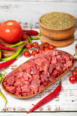 Beef cubed on wood background. Raw beef cubed with herbs and spices