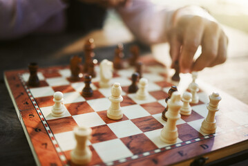 Hands, chess game and board with strategy in competition or challenge, intelligence and closeup of...