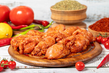 Chicken tenderloin on wood background. Raw chicken tenderloin with herbs and spices
