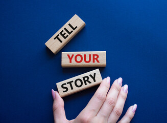 Tell your story symbol. Wooden blocks with words Tell your story. Beautiful deep blue background....