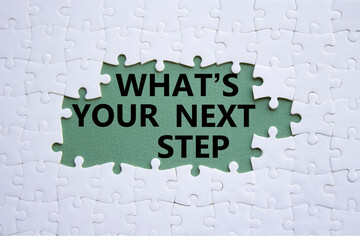 What is your next step symbol. White puzzle with words What is your next step. Beautiful grey green background. Business concept. Copy space.