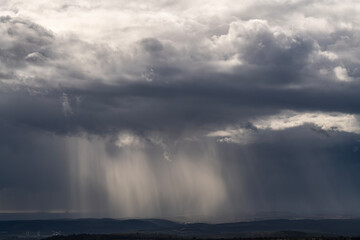 Sun rays shining through rainclouds showing the falling rain in Northern Israel looking towards the...