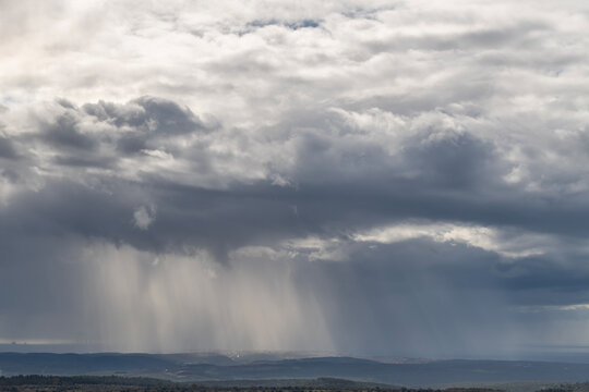 Sun rays shining through rainclouds showing the falling rain in Northern Israel looking towards the Mediterranean Sea from Muhraqa viewpoint.
