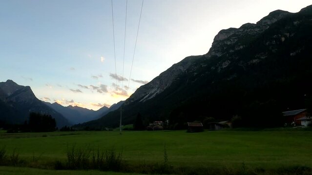 Mountains in Austria at the Brenner Pass at dusk with meadows and forests in 4k